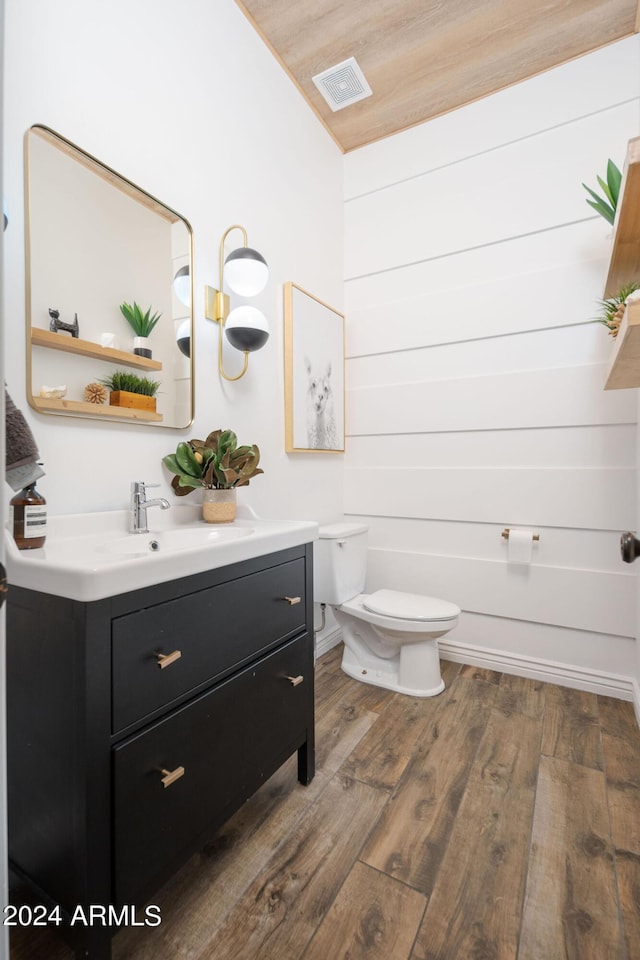 bathroom featuring visible vents, vanity, toilet, and wood finished floors