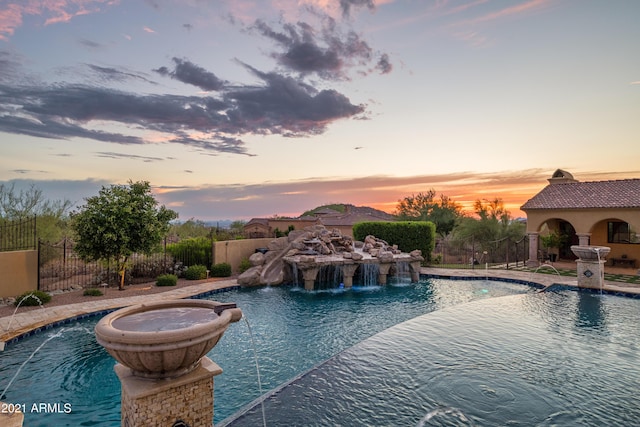 pool at dusk with pool water feature