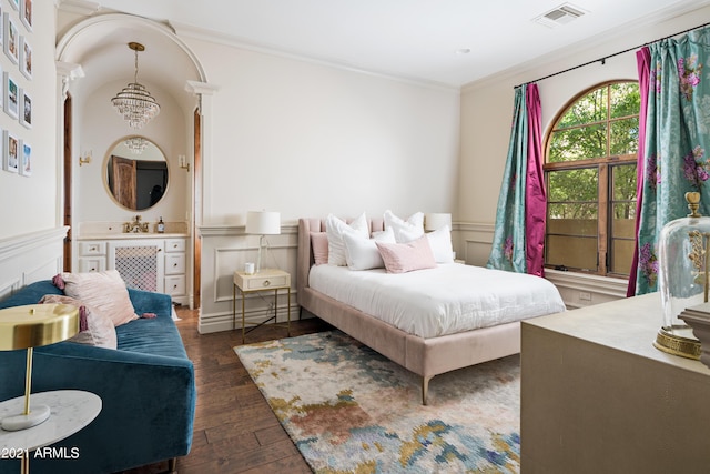 bedroom featuring a notable chandelier, ornamental molding, and dark wood-type flooring