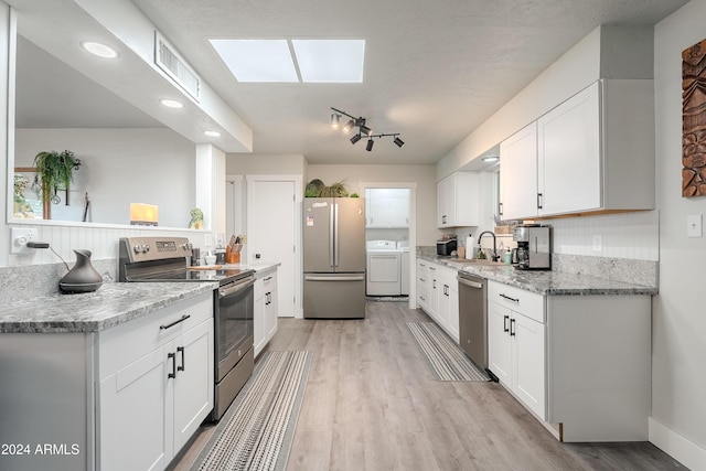 kitchen featuring sink, light hardwood / wood-style flooring, appliances with stainless steel finishes, light stone counters, and white cabinetry