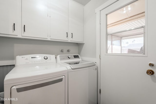 laundry room with separate washer and dryer and cabinets