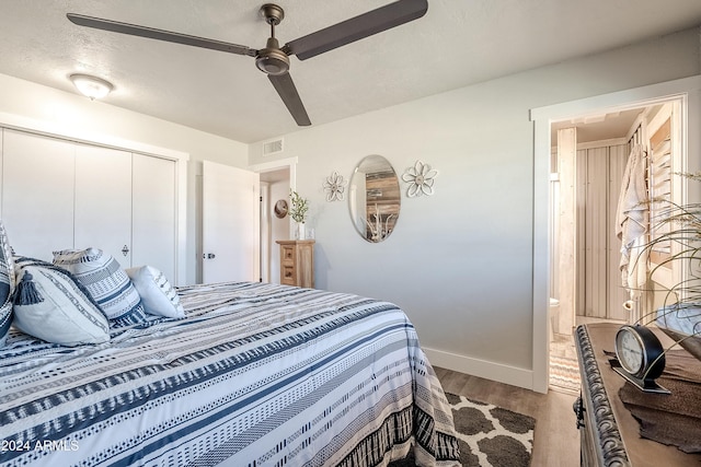 bedroom featuring a textured ceiling, light hardwood / wood-style floors, a closet, and ceiling fan