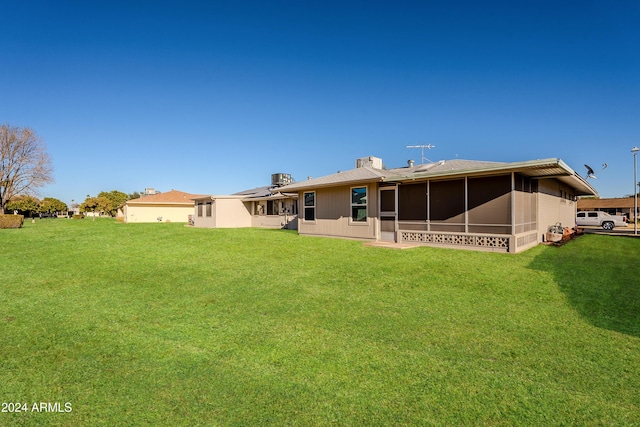 back of house featuring a sunroom and a yard