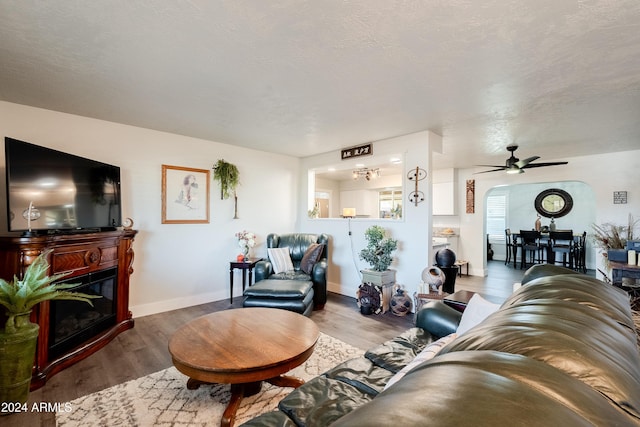 living room featuring hardwood / wood-style floors, a textured ceiling, and ceiling fan