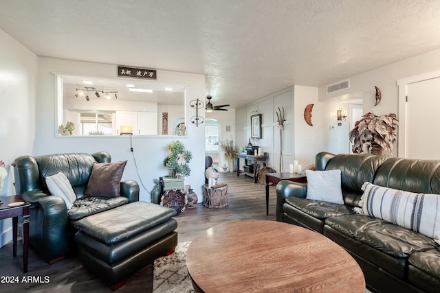 living room with wood-type flooring, a textured ceiling, and ceiling fan