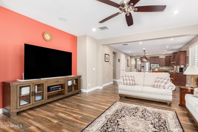 living room with ceiling fan and dark wood-type flooring