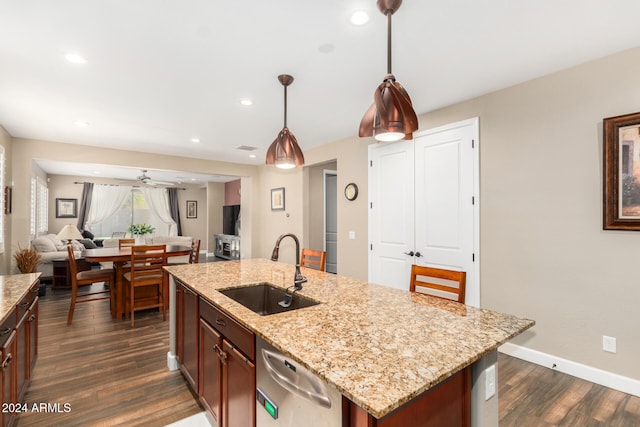 kitchen featuring a center island with sink, sink, dark hardwood / wood-style floors, ceiling fan, and decorative light fixtures