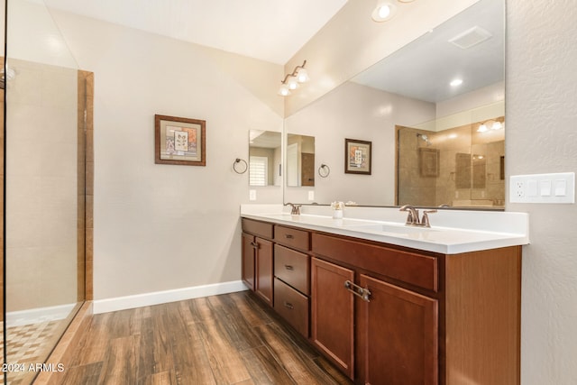 bathroom with a tile shower, hardwood / wood-style floors, and vanity