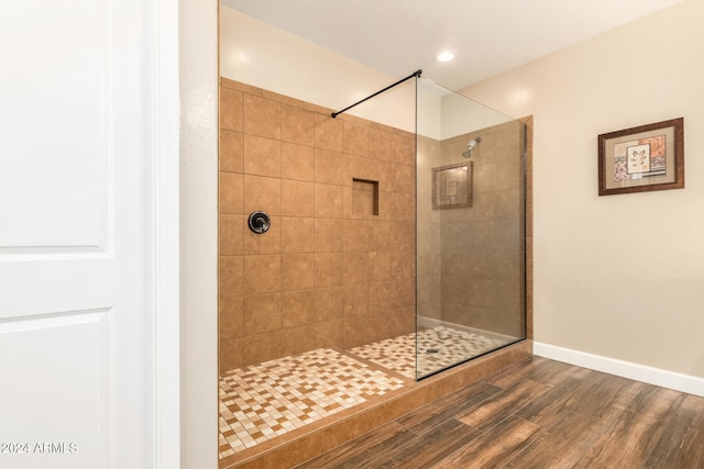 bathroom with hardwood / wood-style floors and a tile shower