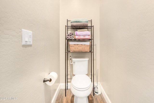 bathroom with hardwood / wood-style flooring and toilet