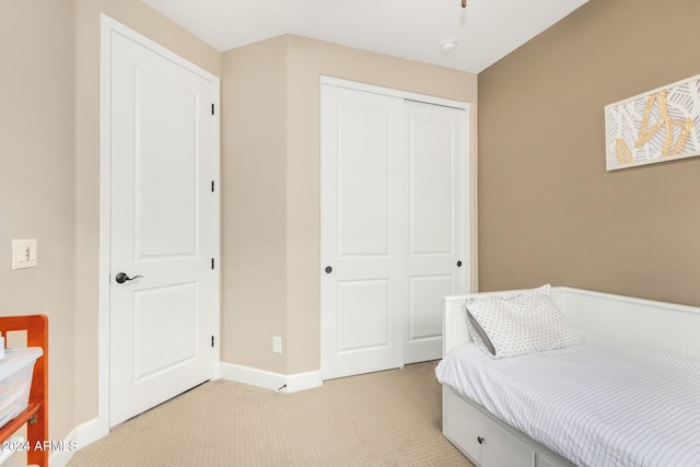 bedroom featuring light carpet and a closet