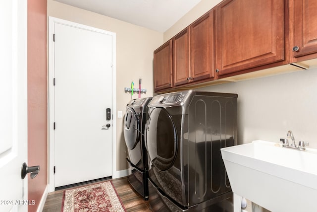 washroom featuring cabinets, dark hardwood / wood-style flooring, washing machine and dryer, and sink