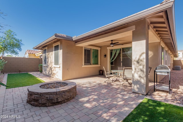 view of patio / terrace with ceiling fan and a fire pit