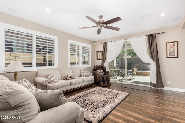 living room featuring ceiling fan and dark wood-type flooring