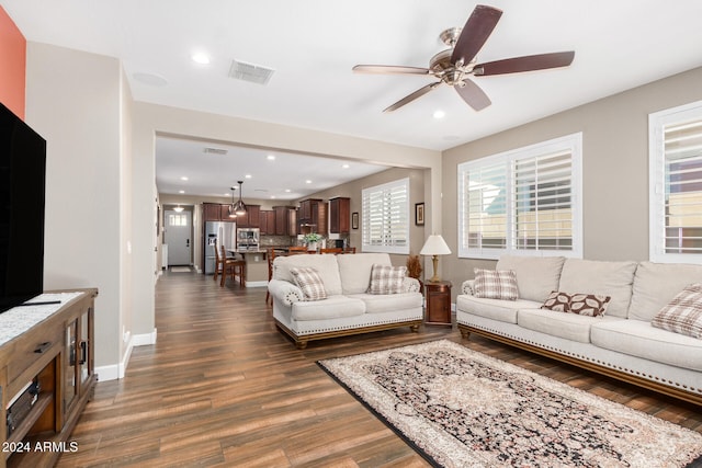 living room featuring ceiling fan and dark wood-type flooring