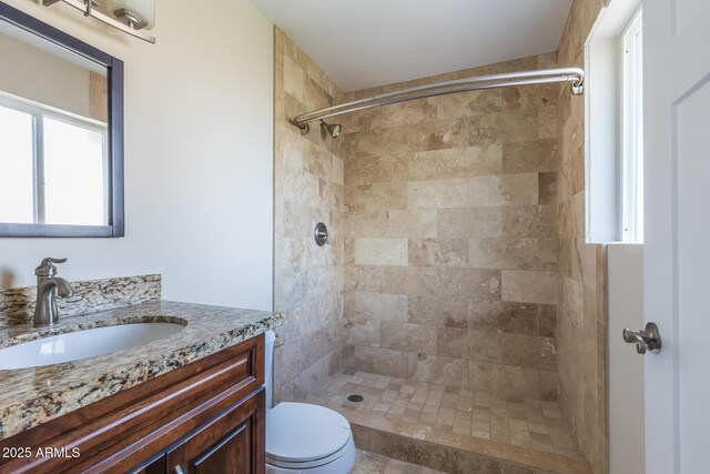 full bath with vanity, toilet, and a tile shower