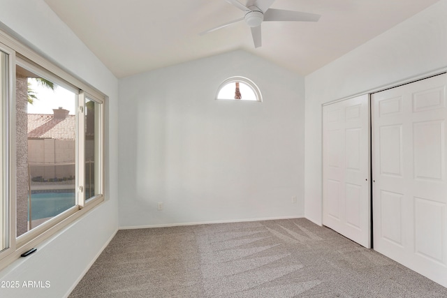 carpeted empty room featuring ceiling fan and lofted ceiling