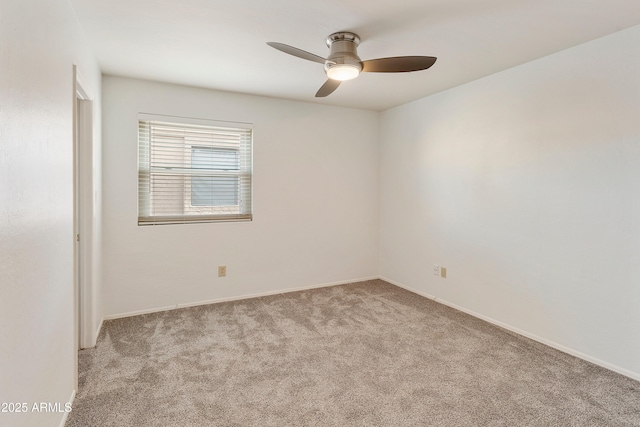 spare room with ceiling fan and light colored carpet