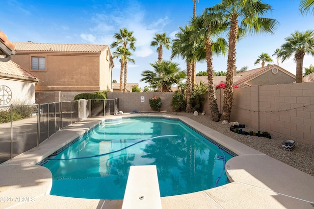 view of swimming pool with a diving board