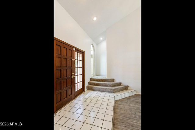 entryway featuring light tile patterned flooring and vaulted ceiling