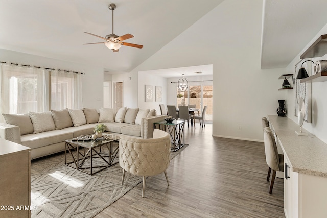 living room featuring wood-type flooring, ceiling fan with notable chandelier, and high vaulted ceiling