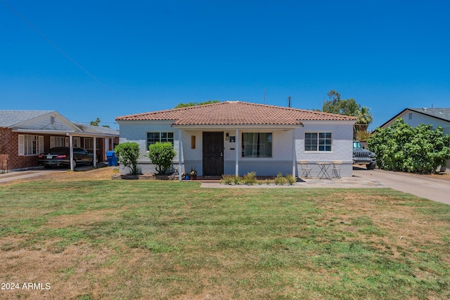 view of front of home with a front yard and a carport