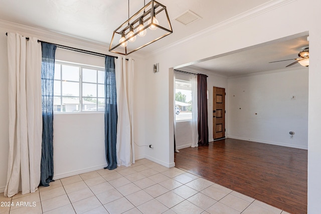 spare room featuring ceiling fan, light tile patterned floors, and ornamental molding