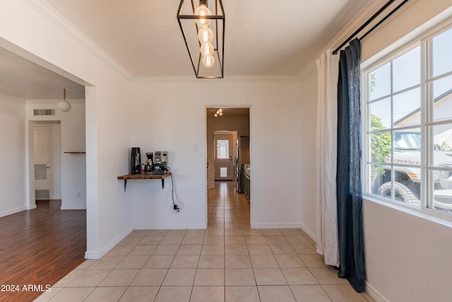 hallway featuring crown molding and light tile patterned floors