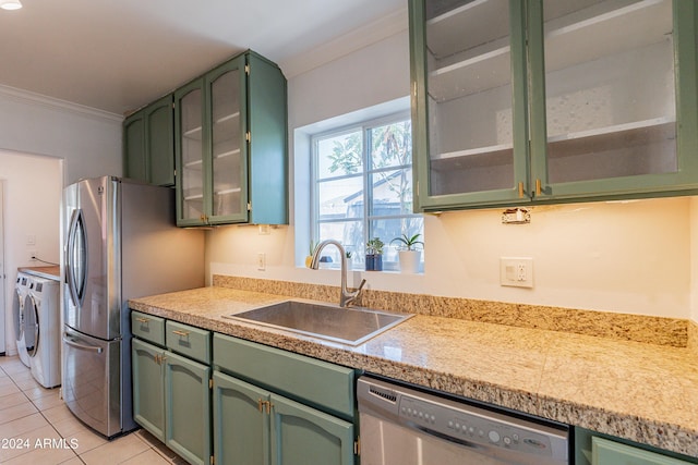 kitchen with sink, ornamental molding, green cabinetry, and appliances with stainless steel finishes