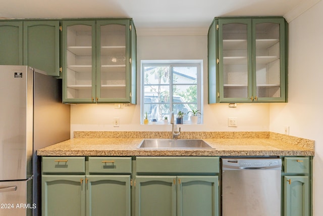 kitchen with crown molding, green cabinets, sink, and stainless steel appliances