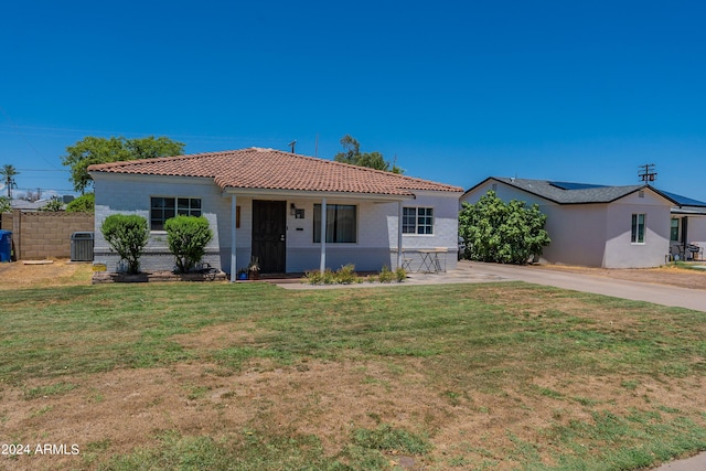 view of front of home with central AC and a front lawn