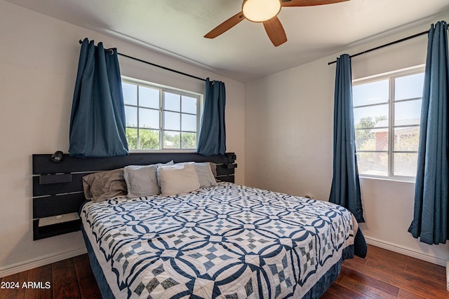 bedroom with multiple windows, dark hardwood / wood-style floors, and ceiling fan