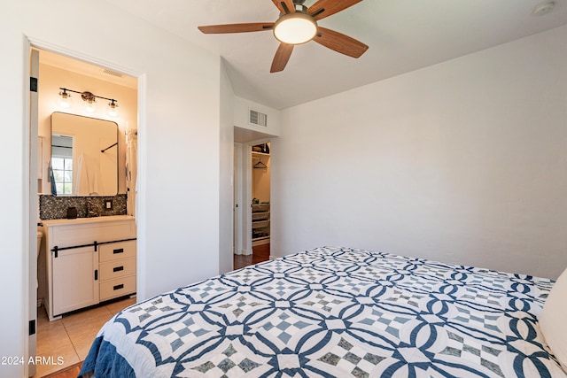 bedroom featuring ceiling fan, light tile patterned flooring, and ensuite bathroom