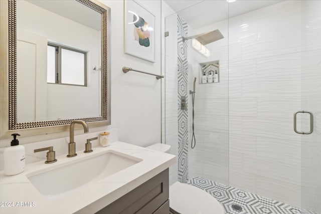 bathroom with vanity, a shower with shower door, and toilet