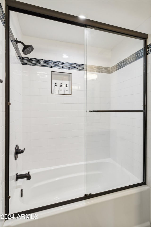 bathroom featuring combined bath / shower with glass door