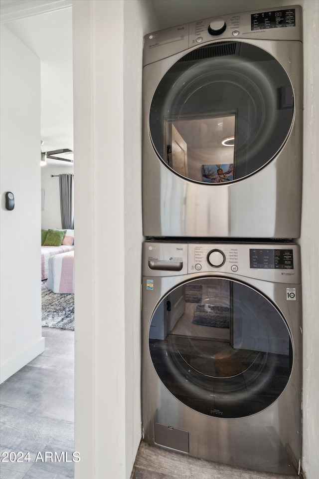 clothes washing area with stacked washer and dryer