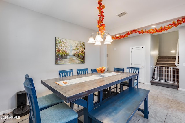 tiled dining room with a notable chandelier