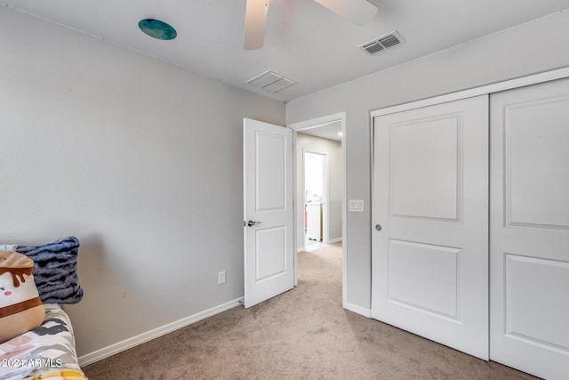 unfurnished bedroom featuring light colored carpet, a closet, and ceiling fan