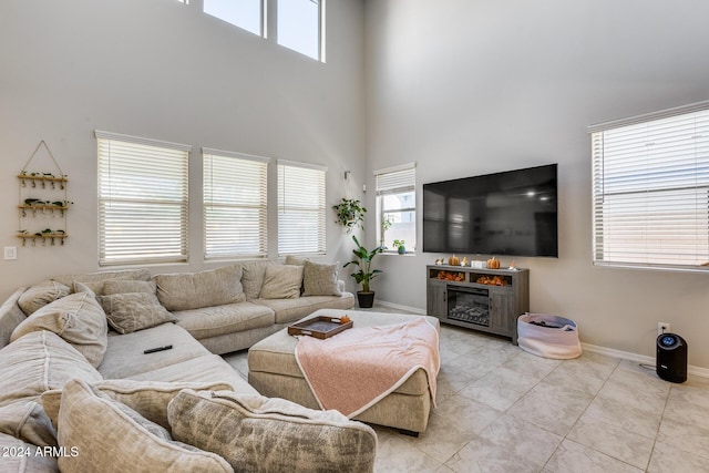 tiled living room with a healthy amount of sunlight and a towering ceiling