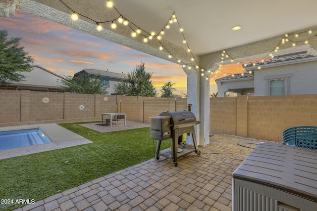 patio terrace at dusk with grilling area and a lawn