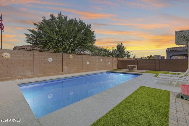 pool at dusk featuring a patio