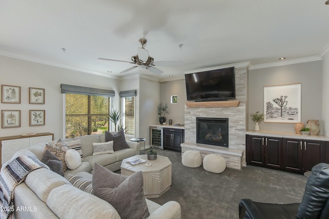 living room featuring ceiling fan, ornamental molding, a large fireplace, dark carpet, and beverage cooler