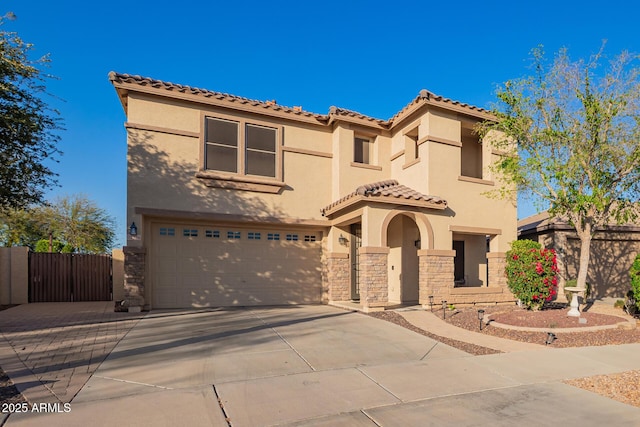 mediterranean / spanish home with concrete driveway, a garage, stone siding, and stucco siding