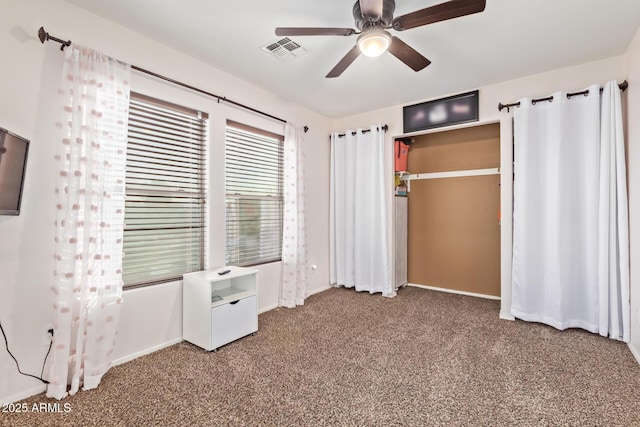 unfurnished bedroom with a closet, visible vents, ceiling fan, and carpet