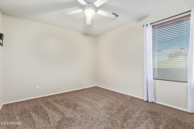 carpeted empty room featuring a ceiling fan and baseboards