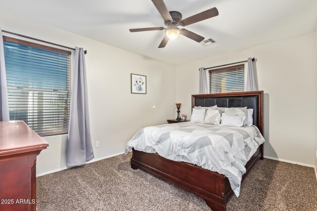 carpeted bedroom featuring visible vents, baseboards, and ceiling fan