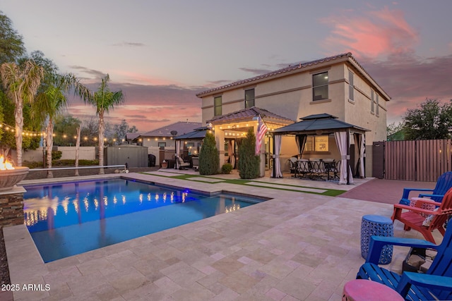 view of pool with a gazebo, a patio area, a fenced backyard, and a gate