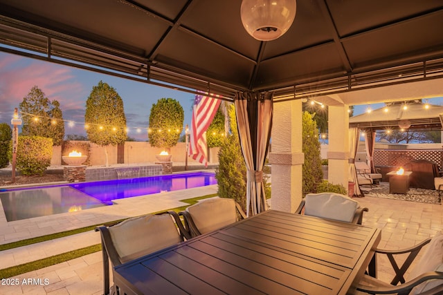 view of patio / terrace with outdoor dining space, a fenced in pool, a fenced backyard, a gazebo, and a fire pit