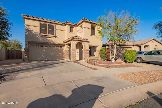 mediterranean / spanish-style home featuring fence, stucco siding, a garage, driveway, and a gate