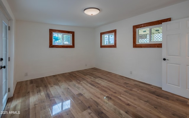 unfurnished room featuring plenty of natural light and wood finished floors